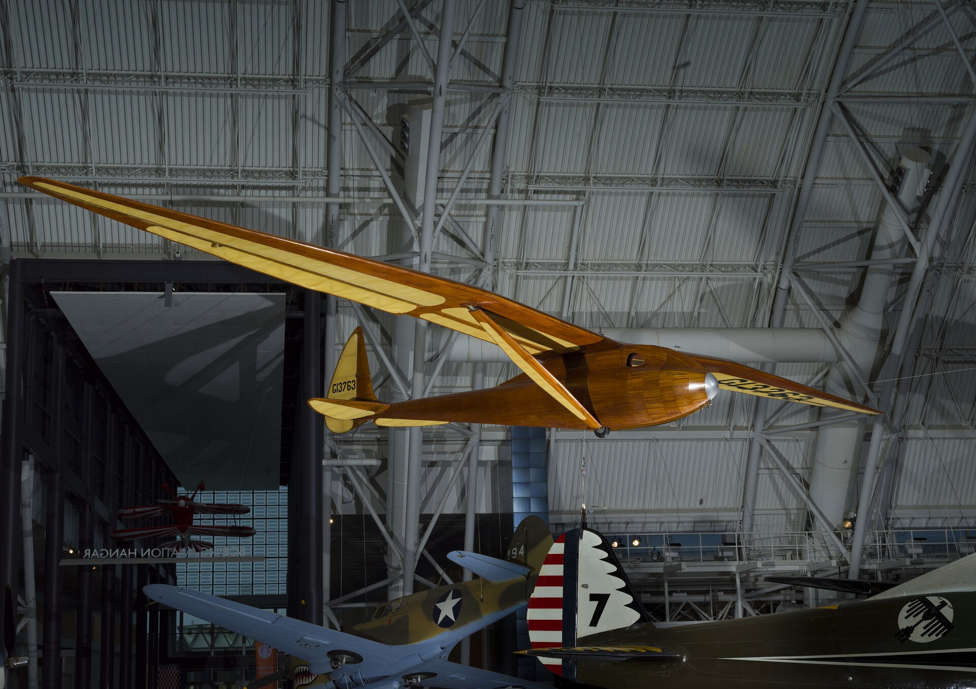 Monoplane glider with strut-braced, gull-type wing mounted high on monocoque fuselage; wooden construction with steel and aluminum fittings and controls; fuselage and wing leading edge covered with mahogany plywood. Fuselage skin applied over laminated Spruce bulkheads. Landing gear consists of single-wheel and .... [size?] tire mounted beneath forward fuselage, spring-steel tail skid beneath rudder. Cockpit covered with hood made from laminated Spruce bulkheads and covered with Mahogany plywood. Circular openings cut into hood on either side of pilot's head. Instrumentation: altimeter, airspeed, variometer plus a bank-and-turn indicator powered by low-speed venturi tube installed on retractable mount beneath right wingroot. Areas aft of wing spar and all control surfaces covered with glider cloth. Cloth is doped directly onto ribs and plywood skin without stitching for smooth finish. Constant-chord wing from fuselage to mid-span, tapered profile from mid-span to wingtip; constant-chord, split-trailing edge flaps and high-aspect ratio ailerons. A Gö 549 airfoil is used at the wing root, becoming symmetrical at the tip. All-flying elevator mounted on duraluminum torque-tube, rudder hinged to box-beam post, both surfaces built up from Spruce and covered with glider cloth. In 1933, Richard C. du Pont teamed with Hawley Bowlus and the two men set up shop in San Fernando, California, to build gliders. Their most successful competition sailplane was the Senior Albatross. The Bowlus shop built four and Warren Eaton bought the third in May 1934. He named the sailplane "Falcon" and flew it often including over the Blue Ridge Mountains from an airfield at Big Meadows, VA, in 1934. Eaton had served in the U. S. Army Air Service during World War I and flown SPAD XIII fighters (see NASM collection) in the 103rd Aero Squadron, 3rd Pursuit Group, at Issoudon, France, from August 27, 1918, until Armistice Day, November 11. Eaton led the effort to found the Soaring Society of America in 1932 and became the organization's first president. Long before he designed and built the Bowlus-du Pont "Falcon," William Hawley Bowlus had contributed to aviation history. In 1926, T. Claude Ryan hired him as factory manager at the Ryan Airlines, Inc., at San Diego, California. Late in February 1927, Bowlus and twenty Ryan workmen, supervised by chief engineer Donald A. Hall and Charles A. Lindbergh, built a long-range monoplane based on the Ryan M-2. Lindbergh christened the modified M-2 the "Spirit of St. Louis." It is said that Bowlus suggested several design features that Lindbergh approved and incorporated in the finished airplane. Bowlus renewed his friendship with Lindbergh late in 1929. He taught the ocean flyer and his wife, Anne Morrow Lindbergh, to fly sailplanes and in January 1930, both Charles and Anne completed their first solo glider flights. Hawley Bowlus developed the Senior Albatross series from a design that he called the Bowlus Super Sailplane. In Germany, designers and pilots led the world in building and flying high-performance gliders and Bowlus was strongly influenced by their work. He and German glider pioneer Martin Schempp taught courses in aircraft design and construction at the Curtiss-Wright Technical Institute in Glendale, California. The two instructors led a group of students who built the Super Sailplane in 1932. The wing of the Super was nearly a copy of the wing used on the German "Wein" sailplane designed and flown with great success in 1930 and 1931 by Robert Kronfeld. Both the Super Sailplane and the Senior Albatross employed the same Goettingen 549 wing airfoil and even the tips of the control surfaces curved to almost identical contours. When Bowlus built the Senior Albatross series, the cockpit enclosure closely resembled another record-setting and influential German sailplane called the "Fafnir" and designed by Alexander Lippisch specifically for pilot Gunther Groenhoff. Richard C. du Pont was also an important character in the history of the Senior Albatross. By the time he finished high school, this heir to the Delaware-based chemical empire could fly gliders with some skill. During his first year at the University of Virginia, he founded a campus soaring club. His passion for motor-less flight drew him farther away from traditional academics and in 1932, he transferred to the Curtiss-Wright Technical Institute. Mr. du Pont was probably among the students who built the Super Albatross. In 1933, du Pont teamed with Hawley Bowlus and the two men set up shop in San Fernando, California, to build gliders. Bowlus furnished the design expertise and performed much of the construction while du Pont supplied enthusiasm, financing, and additional labor. The Bowlus-DuPont Sailplane Company became an official entity in 1934, not in California but in Delaware. The firm folded in September 1936 but during its short life, the small factory built four examples of the Senior Albatross. No two were constructed exactly alike and a short history of each follows: -Prototype Sr Albatross called the Super Sailplane, 60-ft span straight wing, built 1932, landed in the ocean and destroyed fall 1932. -First two production Sr. Albatrosses, 62-ft span gull wing, a single-seat named Albatross I, and a two-seater named Dragonfly with pod fuselage and a metal boom aft fuselage, both with gull wings but no flaps, purchased by Richard du Pont in 1933. Dragonfly crashed at Elmira 1933 and later burned by du Pont. Du Pont sold Albatross I to Chet Decker. -Third production Sr. Albatross built to order for Warren Eaton, named Falcon and fitted with flaps, Eaton accepted the sailplane May 1934, flown at Elmira in national meet that year, Eaton died end of 1934, Eaton’s widow Genevieve donated to Smithsonian Institution in 1935. -Fourth production Sr. Albatross, Bowlus built a sister ship to Eaton’s Falcon called Albatross II and fitted with flaps like Falcon, sold to du Pont who flew it in 1934 national contest at Elmira. Flown many times but not owned by Lew Barringer, damaged by wind in 1935 and wreck sold to Jack O’Meara in 1935. All four sailplanes did have 'gull' wings (each wing was bent down slightly at about mid-span) and this feature differentiates these airplanes from the prototype Super Sailplane. Bowlus fitted two with wing flaps, Falcon and Albatross II, rather than spoilers, for better speed and altitude control during landing. Mahogany plywood skinned the Falcon and spruce plywood covered the other three aircraft, Dragonfly, Albatross I, and Albatross II. Bowlus sold each of these handcrafted airplanes for $2,500. Performance calculations revealed a best glide ratio of 23:1 when flying at 64.4 km/h (40 mph). If it became necessary, the pilot of a Senior Albatross could push his mount well over 161 km/h (100 mph) as long as he never exceeded a speed of 241.5 km/h (150 mph). With an accomplished pilot at the controls, the Senior Albatross could fly better than any other American sailplane and they were very pleasing to look at, too. A quotation from the July 1934 issue of "Aviation," a popular aviation periodical of the day, sums up one writer's impressions of the Senior Albatross: "Few flying machines have ever exhibited such an extraordinary combination of workmanship, finish, and aerodynamic refinement, so that it seems quite safe to say that the new ships represent the ultimate in soaring design practice in the United States, if not the world." The pilots who flew the Senior Albatross nearly dominated American competitive soaring. In September 1933, Richard du Pont flew the first Senior Albatross, Albatross I, at the fourth U. S. National Soaring Championships held at Elmira, New York. On September 21, du Pont set the American sailplane distance record by flying 196 km (121.6 miles). On June 25, 1934, he flew to within 3.2 km (2 miles) of New York City and established a new world distance record of 254 km (158 miles). On June 30, 1934, du Pont set the U. S. altitude record for sailplanes by climbing to 1,892 m (6,223 ft). The following year, Lewin Barringer soared du Pont’s Albatross II parallel to the ridges of the Allegheny Mountains for 250.3 km (155.5 miles). Du Pont sold Albatross I to Chet Decker who competed with the sailplane in the 1936 U. S. National contest held at Elmira, NY. In May 1934, Warren E. Eaton acquired from Hawley Bowlus the Senior Albatross Falcon that is now preserved at NASM. Eaton was already a veteran aviator. He had joined the U. S. Army Air Service and flown SPAD XIII fighters (see NASM collection) in the 103rd Aero Squadron, 3rd Pursuit Group, at Issoudon, France, from August 27, 1918, until Armistice Day, November 11. He was credited with downing one enemy aircraft in aerial combat. After the war, Eaton founded the Soaring Society of America and became the organization's first president. Eaton had commissioned Bowlus to build a Senior Albatross after he saw Richard du Pont fly the Albatross I at the U. S. Nationals the year before. Eaton asked Bowlus to fit flaps to his aircraft and to skin it with mahogany plywood. He christened it Falcon and it bore the federal aircraft registration number G13763. Several gold decals edged in black also appeared at various locations on the fuselage. "Warren E. Eaton" and "Falcon" appeared on both sides of the nose. A stylized albatross and the company motto "On the Wings of an Albatross" were applied to the vertical fin above the words "Bowlus-du Pont Sailplane Company." Eaton first flew the glider at San Diego. In June, he brought it to the national contest atop Harris Hill outside Elmira, New York. At Big Meadows, Virginia, Eaton set the American soaring altitude record, 2,765 m (9,094 ft), during September 1934. Three months later, Eaton died in Florida flying a Franklin primay glider. In 1935, Warren Eaton's widow, Genevieve, donated the Falcon to the Smithsonian Institution. It arrived in Washington on May 28 and a few days later, museum personnel suspended the glider from the ceiling of the West Hall of the Arts and Industries Building where it remained on display for many years. Wingspan: 18.8 m (61 ft 9 in) Length: 7.2 m (23 ft 7 in) Height: 1.6 m (5 ft 4 in) Weight: Empty, 153 kg (340 lb) Gross, 236 kg (520 lb) References and Further Reading: Blacksten, Raul. "On the Wings of an (Senior) Albatross." Unpublished manuscript, May 2000. Crouch, Tom D., ed. "Charles A. Lindbergh - An American Life." Washington: Smithsonian Institution Press, 1977. Frebert, George, and Haskell, Debbie, ed. "Deleware Aviation History." Dover: Litho Printing Co., 1998. Ross, Harland. "A Bowlus Outline," "Bungee Cord," Vol. 6 No. 4, Winter 1980. Simons, Martin. "The World's Vintage Sailplanes 1908-1945." Melbourne, Australia: Kookaburra, 1986. Senior Albatross curatorial file, Aeronautics Division, National Air and Space Museum. Russell Lee, 7/23/12, rev. 11/5/20