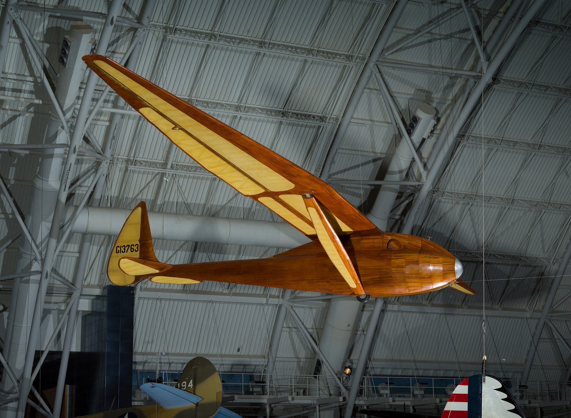 Monoplane glider with strut-braced, gull-type wing mounted high on monocoque fuselage; wooden construction with steel and aluminum fittings and controls; fuselage and wing leading edge covered with mahogany plywood. Fuselage skin applied over laminated Spruce bulkheads. Landing gear consists of single-wheel and .... [size?] tire mounted beneath forward fuselage, spring-steel tail skid beneath rudder. Cockpit covered with hood made from laminated Spruce bulkheads and covered with Mahogany plywood. Circular openings cut into hood on either side of pilot's head. Instrumentation: altimeter, airspeed, variometer plus a bank-and-turn indicator powered by low-speed venturi tube installed on retractable mount beneath right wingroot. Areas aft of wing spar and all control surfaces covered with glider cloth. Cloth is doped directly onto ribs and plywood skin without stitching for smooth finish. Constant-chord wing from fuselage to mid-span, tapered profile from mid-span to wingtip; constant-chord, split-trailing edge flaps and high-aspect ratio ailerons. A Gö 549 airfoil is used at the wing root, becoming symmetrical at the tip. All-flying elevator mounted on duraluminum torque-tube, rudder hinged to box-beam post, both surfaces built up from Spruce and covered with glider cloth. In 1933, Richard C. du Pont teamed with Hawley Bowlus and the two men set up shop in San Fernando, California, to build gliders. Their most successful competition sailplane was the Senior Albatross. The Bowlus shop built four and Warren Eaton bought the third in May 1934. He named the sailplane "Falcon" and flew it often including over the Blue Ridge Mountains from an airfield at Big Meadows, VA, in 1934. Eaton had served in the U. S. Army Air Service during World War I and flown SPAD XIII fighters (see NASM collection) in the 103rd Aero Squadron, 3rd Pursuit Group, at Issoudon, France, from August 27, 1918, until Armistice Day, November 11. Eaton led the effort to found the Soaring Society of America in 1932 and became the organization's first president. Long before he designed and built the Bowlus-du Pont "Falcon," William Hawley Bowlus had contributed to aviation history. In 1926, T. Claude Ryan hired him as factory manager at the Ryan Airlines, Inc., at San Diego, California. Late in February 1927, Bowlus and twenty Ryan workmen, supervised by chief engineer Donald A. Hall and Charles A. Lindbergh, built a long-range monoplane based on the Ryan M-2. Lindbergh christened the modified M-2 the "Spirit of St. Louis." It is said that Bowlus suggested several design features that Lindbergh approved and incorporated in the finished airplane. Bowlus renewed his friendship with Lindbergh late in 1929. He taught the ocean flyer and his wife, Anne Morrow Lindbergh, to fly sailplanes and in January 1930, both Charles and Anne completed their first solo glider flights. Hawley Bowlus developed the Senior Albatross series from a design that he called the Bowlus Super Sailplane. In Germany, designers and pilots led the world in building and flying high-performance gliders and Bowlus was strongly influenced by their work. He and German glider pioneer Martin Schempp taught courses in aircraft design and construction at the Curtiss-Wright Technical Institute in Glendale, California. The two instructors led a group of students who built the Super Sailplane in 1932. The wing of the Super was nearly a copy of the wing used on the German "Wein" sailplane designed and flown with great success in 1930 and 1931 by Robert Kronfeld. Both the Super Sailplane and the Senior Albatross employed the same Goettingen 549 wing airfoil and even the tips of the control surfaces curved to almost identical contours. When Bowlus built the Senior Albatross series, the cockpit enclosure closely resembled another record-setting and influential German sailplane called the "Fafnir" and designed by Alexander Lippisch specifically for pilot Gunther Groenhoff. Richard C. du Pont was also an important character in the history of the Senior Albatross. By the time he finished high school, this heir to the Delaware-based chemical empire could fly gliders with some skill. During his first year at the University of Virginia, he founded a campus soaring club. His passion for motor-less flight drew him farther away from traditional academics and in 1932, he transferred to the Curtiss-Wright Technical Institute. Mr. du Pont was probably among the students who built the Super Albatross. In 1933, du Pont teamed with Hawley Bowlus and the two men set up shop in San Fernando, California, to build gliders. Bowlus furnished the design expertise and performed much of the construction while du Pont supplied enthusiasm, financing, and additional labor. The Bowlus-DuPont Sailplane Company became an official entity in 1934, not in California but in Delaware. The firm folded in September 1936 but during its short life, the small factory built four examples of the Senior Albatross. No two were constructed exactly alike and a short history of each follows: -Prototype Sr Albatross called the Super Sailplane, 60-ft span straight wing, built 1932, landed in the ocean and destroyed fall 1932. -First two production Sr. Albatrosses, 62-ft span gull wing, a single-seat named Albatross I, and a two-seater named Dragonfly with pod fuselage and a metal boom aft fuselage, both with gull wings but no flaps, purchased by Richard du Pont in 1933. Dragonfly crashed at Elmira 1933 and later burned by du Pont. Du Pont sold Albatross I to Chet Decker. -Third production Sr. Albatross built to order for Warren Eaton, named Falcon and fitted with flaps, Eaton accepted the sailplane May 1934, flown at Elmira in national meet that year, Eaton died end of 1934, Eaton’s widow Genevieve donated to Smithsonian Institution in 1935. -Fourth production Sr. Albatross, Bowlus built a sister ship to Eaton’s Falcon called Albatross II and fitted with flaps like Falcon, sold to du Pont who flew it in 1934 national contest at Elmira. Flown many times but not owned by Lew Barringer, damaged by wind in 1935 and wreck sold to Jack O’Meara in 1935. All four sailplanes did have 'gull' wings (each wing was bent down slightly at about mid-span) and this feature differentiates these airplanes from the prototype Super Sailplane. Bowlus fitted two with wing flaps, Falcon and Albatross II, rather than spoilers, for better speed and altitude control during landing. Mahogany plywood skinned the Falcon and spruce plywood covered the other three aircraft, Dragonfly, Albatross I, and Albatross II. Bowlus sold each of these handcrafted airplanes for $2,500. Performance calculations revealed a best glide ratio of 23:1 when flying at 64.4 km/h (40 mph). If it became necessary, the pilot of a Senior Albatross could push his mount well over 161 km/h (100 mph) as long as he never exceeded a speed of 241.5 km/h (150 mph). With an accomplished pilot at the controls, the Senior Albatross could fly better than any other American sailplane and they were very pleasing to look at, too. A quotation from the July 1934 issue of "Aviation," a popular aviation periodical of the day, sums up one writer's impressions of the Senior Albatross: "Few flying machines have ever exhibited such an extraordinary combination of workmanship, finish, and aerodynamic refinement, so that it seems quite safe to say that the new ships represent the ultimate in soaring design practice in the United States, if not the world." The pilots who flew the Senior Albatross nearly dominated American competitive soaring. In September 1933, Richard du Pont flew the first Senior Albatross, Albatross I, at the fourth U. S. National Soaring Championships held at Elmira, New York. On September 21, du Pont set the American sailplane distance record by flying 196 km (121.6 miles). On June 25, 1934, he flew to within 3.2 km (2 miles) of New York City and established a new world distance record of 254 km (158 miles). On June 30, 1934, du Pont set the U. S. altitude record for sailplanes by climbing to 1,892 m (6,223 ft). The following year, Lewin Barringer soared du Pont’s Albatross II parallel to the ridges of the Allegheny Mountains for 250.3 km (155.5 miles). Du Pont sold Albatross I to Chet Decker who competed with the sailplane in the 1936 U. S. National contest held at Elmira, NY. In May 1934, Warren E. Eaton acquired from Hawley Bowlus the Senior Albatross Falcon that is now preserved at NASM. Eaton was already a veteran aviator. He had joined the U. S. Army Air Service and flown SPAD XIII fighters (see NASM collection) in the 103rd Aero Squadron, 3rd Pursuit Group, at Issoudon, France, from August 27, 1918, until Armistice Day, November 11. He was credited with downing one enemy aircraft in aerial combat. After the war, Eaton founded the Soaring Society of America and became the organization's first president. Eaton had commissioned Bowlus to build a Senior Albatross after he saw Richard du Pont fly the Albatross I at the U. S. Nationals the year before. Eaton asked Bowlus to fit flaps to his aircraft and to skin it with mahogany plywood. He christened it Falcon and it bore the federal aircraft registration number G13763. Several gold decals edged in black also appeared at various locations on the fuselage. "Warren E. Eaton" and "Falcon" appeared on both sides of the nose. A stylized albatross and the company motto "On the Wings of an Albatross" were applied to the vertical fin above the words "Bowlus-du Pont Sailplane Company." Eaton first flew the glider at San Diego. In June, he brought it to the national contest atop Harris Hill outside Elmira, New York. At Big Meadows, Virginia, Eaton set the American soaring altitude record, 2,765 m (9,094 ft), during September 1934. Three months later, Eaton died in Florida flying a Franklin primay glider. In 1935, Warren Eaton's widow, Genevieve, donated the Falcon to the Smithsonian Institution. It arrived in Washington on May 28 and a few days later, museum personnel suspended the glider from the ceiling of the West Hall of the Arts and Industries Building where it remained on display for many years. Wingspan: 18.8 m (61 ft 9 in) Length: 7.2 m (23 ft 7 in) Height: 1.6 m (5 ft 4 in) Weight: Empty, 153 kg (340 lb) Gross, 236 kg (520 lb) References and Further Reading: Blacksten, Raul. "On the Wings of an (Senior) Albatross." Unpublished manuscript, May 2000. Crouch, Tom D., ed. "Charles A. Lindbergh - An American Life." Washington: Smithsonian Institution Press, 1977. Frebert, George, and Haskell, Debbie, ed. "Deleware Aviation History." Dover: Litho Printing Co., 1998. Ross, Harland. "A Bowlus Outline," "Bungee Cord," Vol. 6 No. 4, Winter 1980. Simons, Martin. "The World's Vintage Sailplanes 1908-1945." Melbourne, Australia: Kookaburra, 1986. Senior Albatross curatorial file, Aeronautics Division, National Air and Space Museum. Russell Lee, 7/23/12, rev. 11/5/20